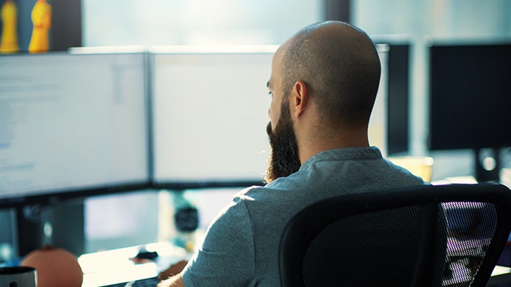 A person looking at a dual screen